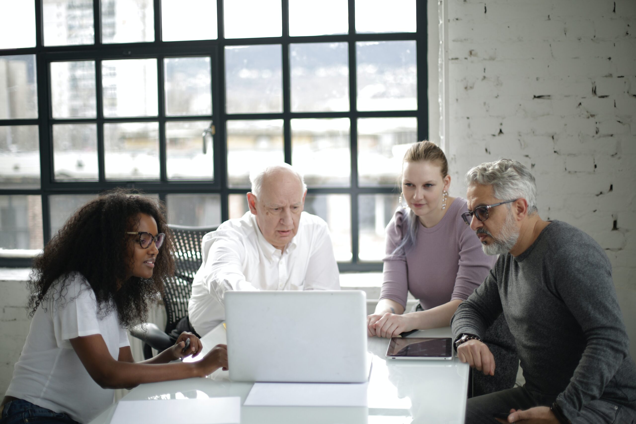 man-in-white-long-sleeved-shirt-presenting-on-a-laptop-3931446